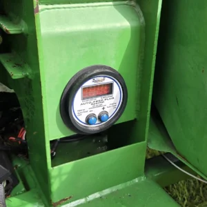 Round digital feed meter on green machinery
